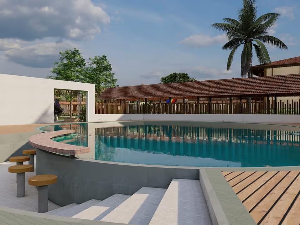 A resort with a pool area, including steps leading into the water and surrounding buildings, under a partly cloudy sky.| Ayana Resorts & Convention, Hyderabad