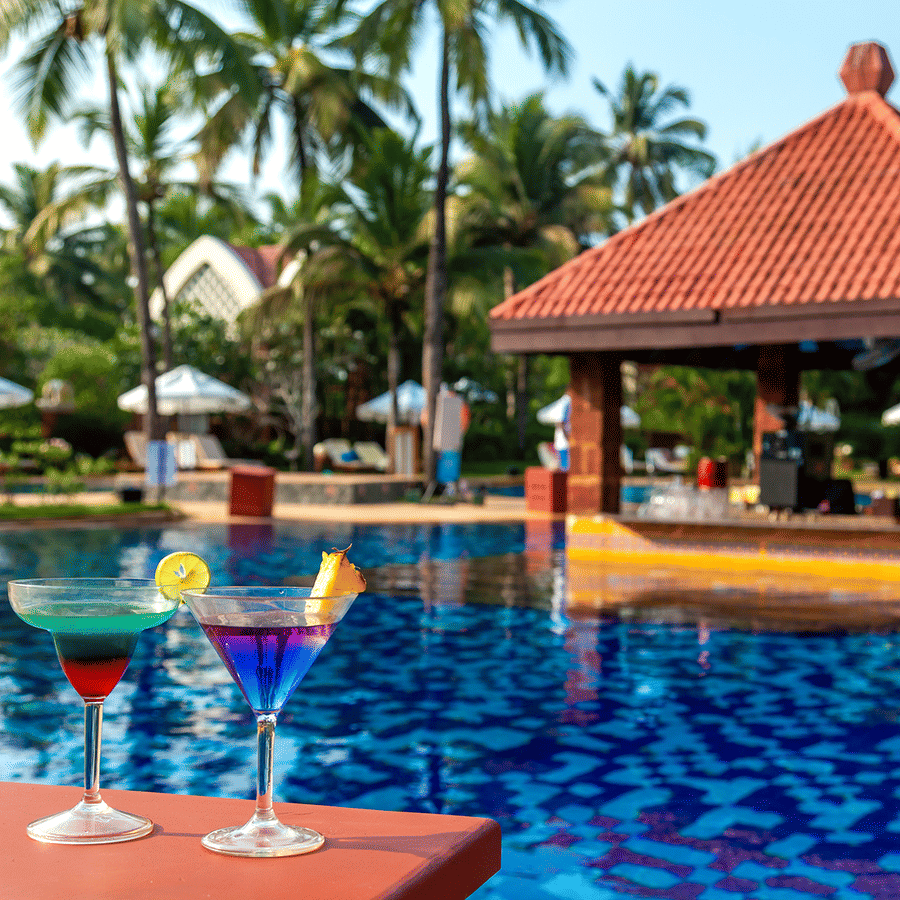 Pool bar featuring 2 cokctails and a swim up bar during daytime - Caravela Beach Resort Goa