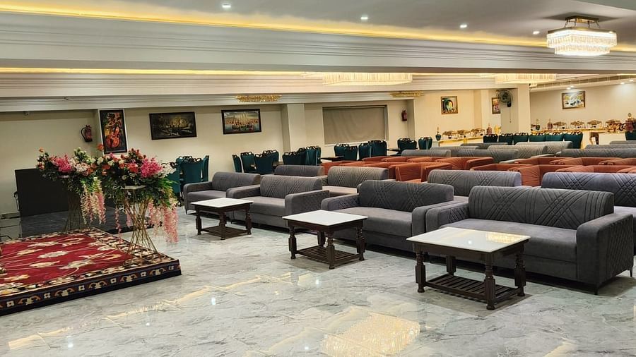 Side view image of Banquet hall at Clarks Inn Bathinda with blue sofas and tables| Clarks Inn Bathinda