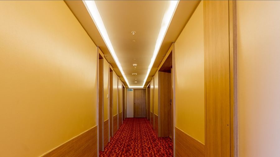 Long, well-lit corridor in a hotel with a red carpet | Gemini Continental