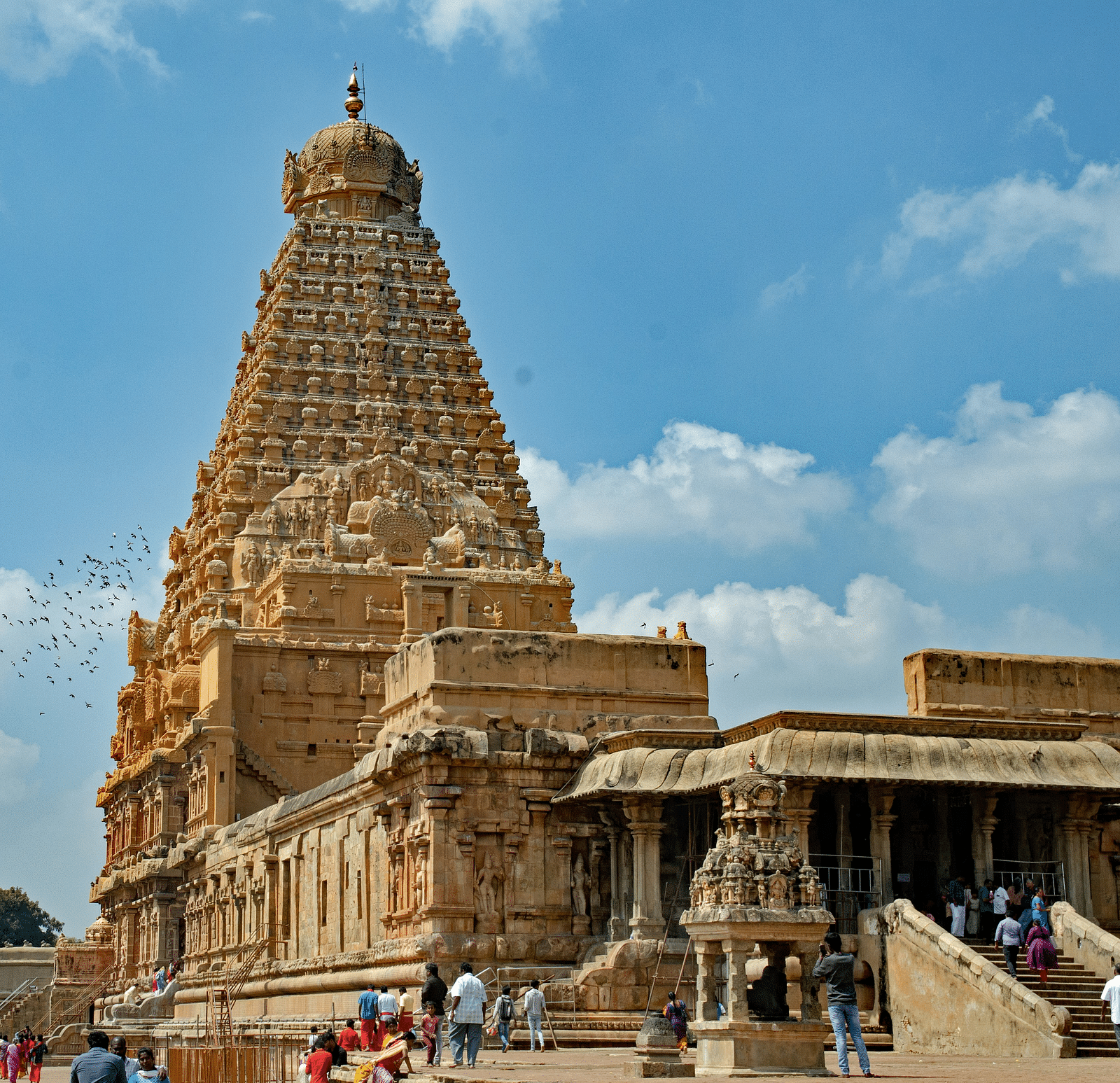 Exterior of Kailasanathar Temple with people walking at the entrance.