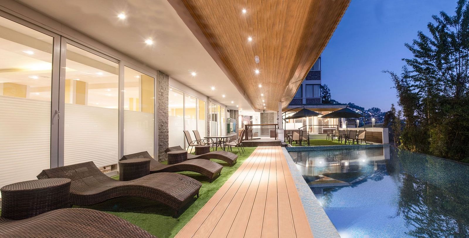 A night time view of a pool with sun loungers placed on its deck - Summit North Star, Gangtok