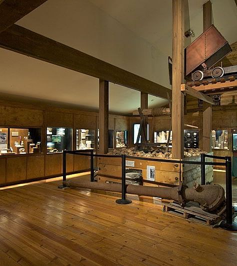 Interiors of a museum with wooden theme and a construction equipment placed in the middle.