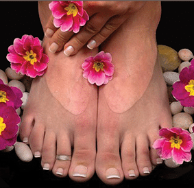 Two closely placed feminine feet with floral decorations on a black backgroung