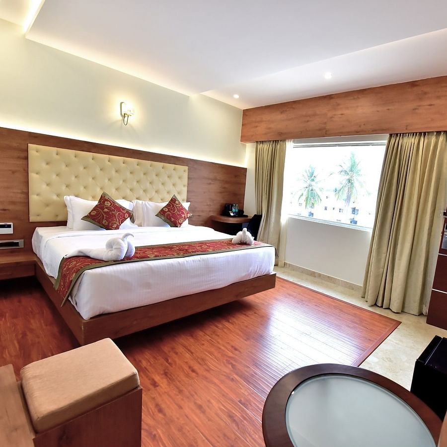 full view of standard room featuring a queen size bed and room amenities like a television a wardrobe etc. along with floor to ceiling windows - Royal Lotus View Resotel1
