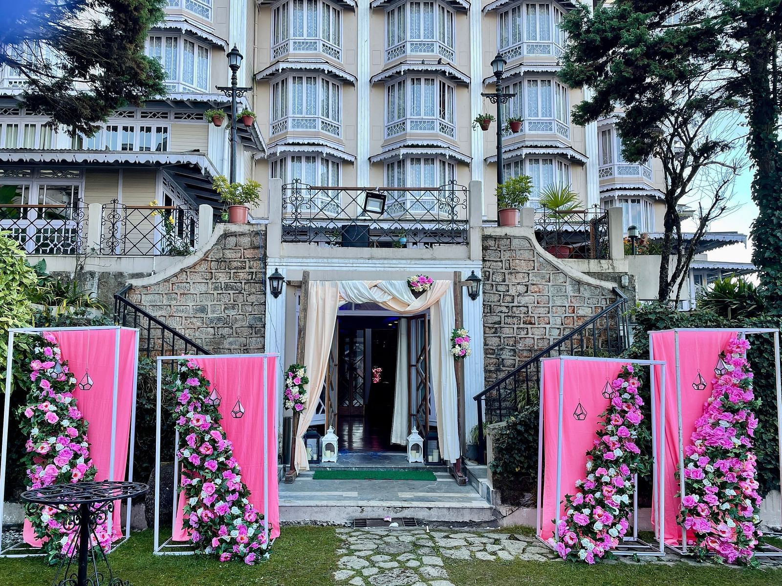 Wedding entrance decor at Cedar Inn, Darjeeling, showcasing the lawn area with floral arrangements and the property's charming exterior.