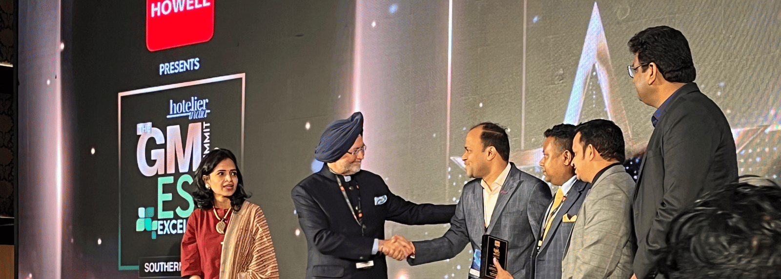 Chief guest congratulating the winner in an award ceremony.