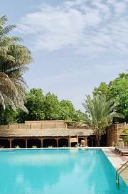 An image of a swimming pool with lounges near it and greenery around - MANVAR Resort & Desert Camp