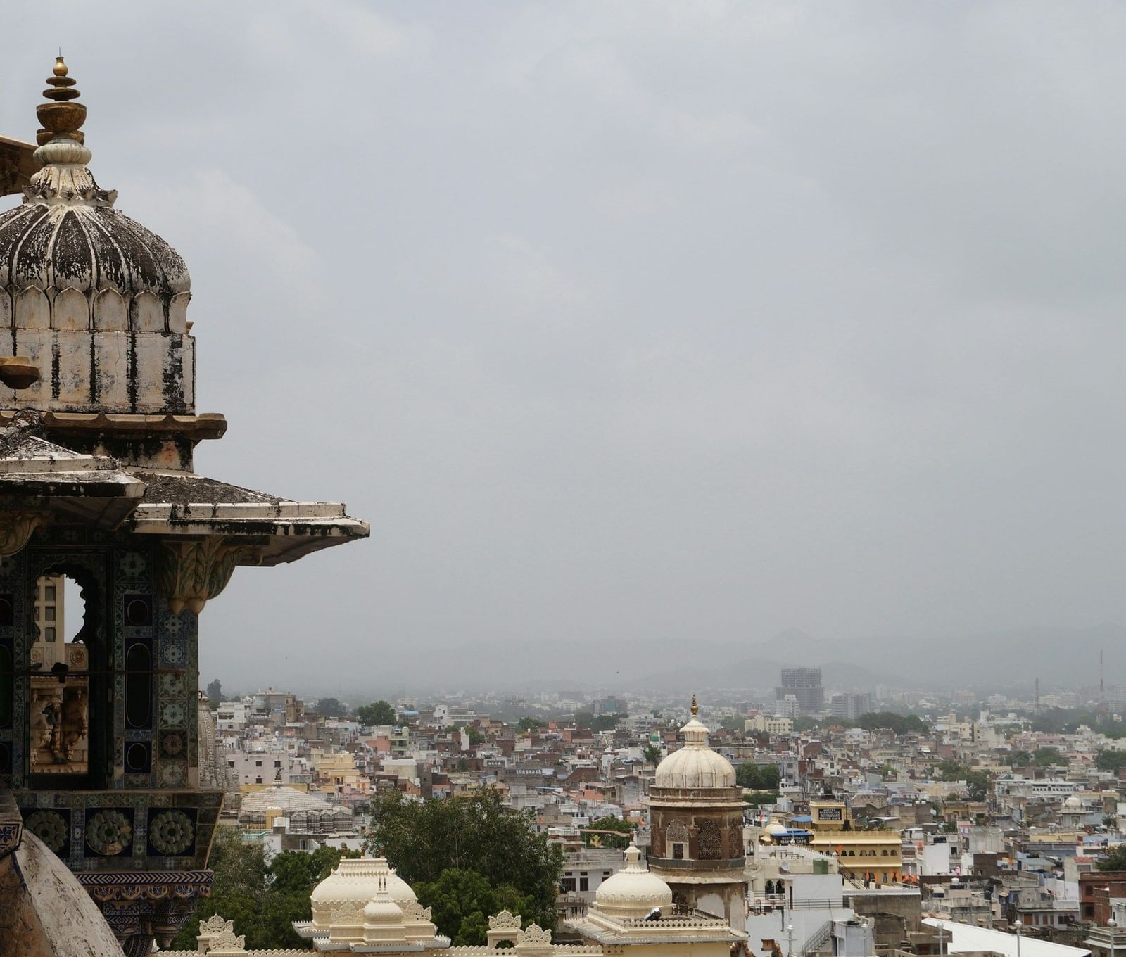 A view from a fort of an old building with a city view of many buildings.