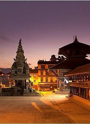 An overview of Bhaktapur Durbar Square in the night with the lights on during the twilight sky