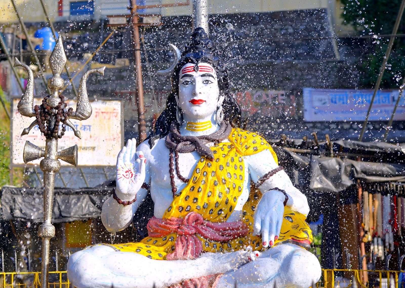 Shiva's idol kept on a pedestal in open air setting with his trident next to him.