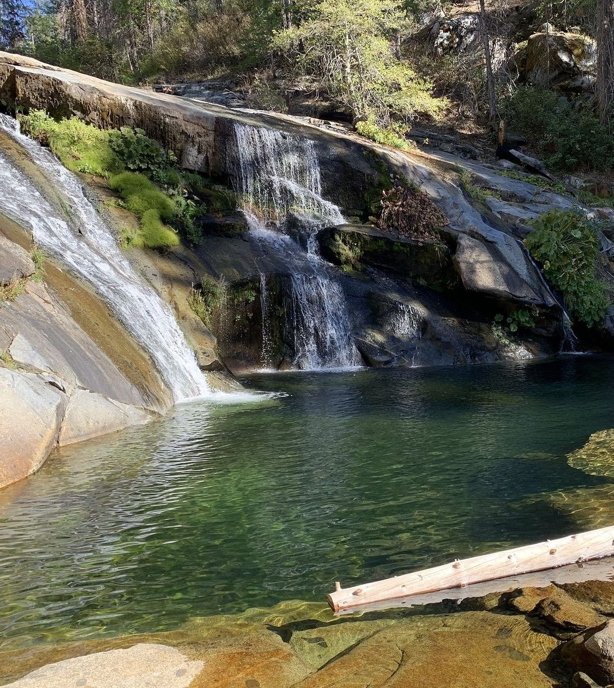 Image of Carlon Falls, showcasing cascading water flowing into a serene pond, surrounded by lush trees