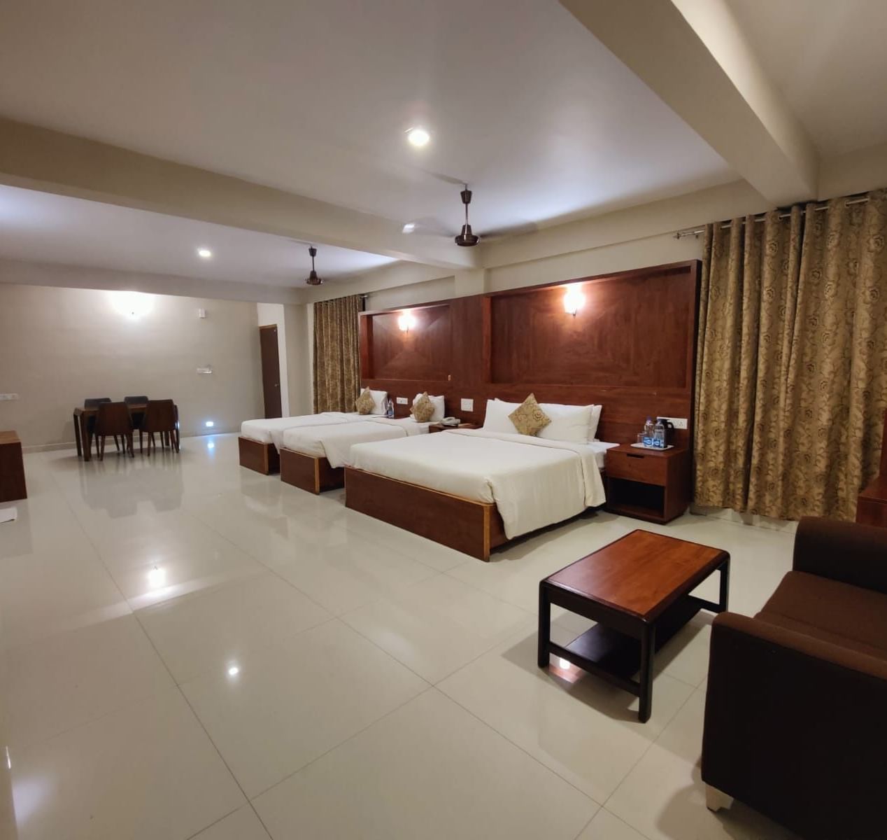 Spacious Deluxe Family Room at Woodstock Resorts, Coorg with twin beds, wooden furniture, and bright, airy interiors.