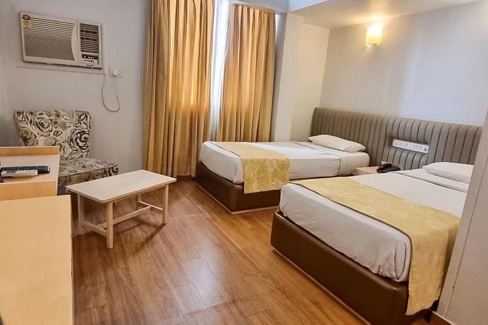 alt-text Standard room with twin beds and a TV at Hotel Diplomat