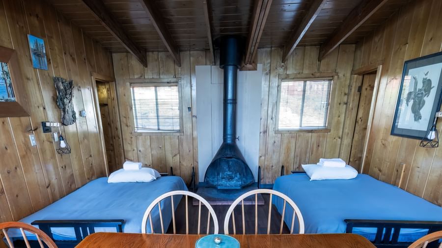 Cabin dining room with wood stove, dark blue table, and rustic wood interiors at Kit Carson Lodge.