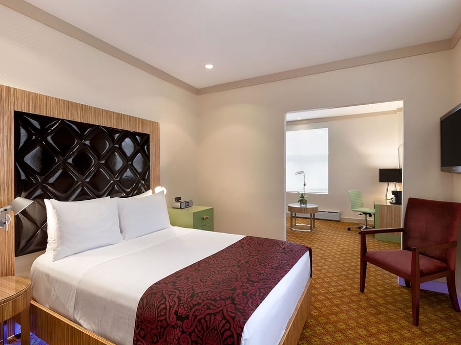 A suite with a comfortable bed, chair and television