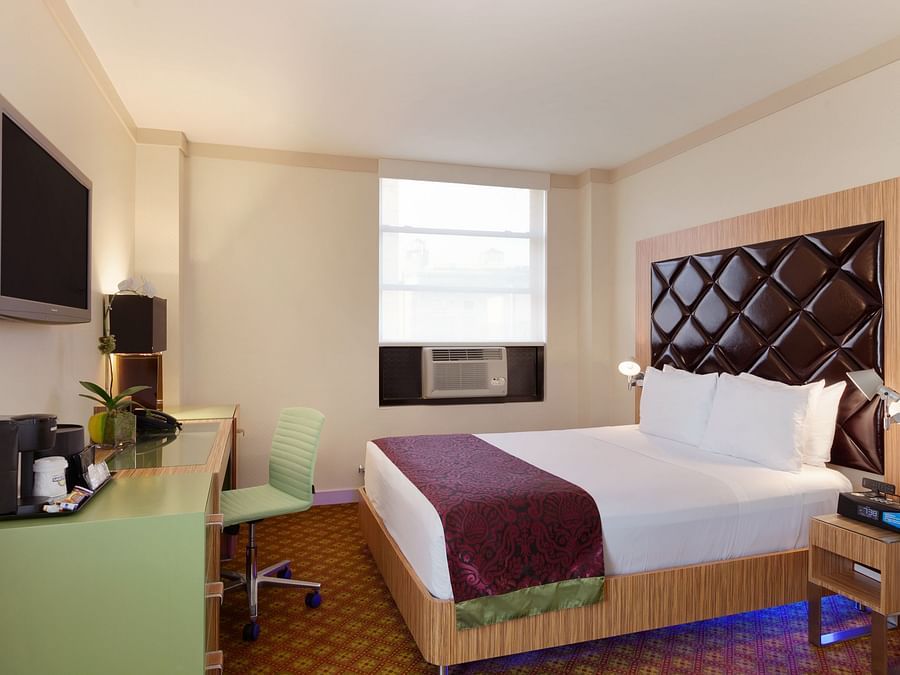 Window side rooms featuring a bed, television and a night stand