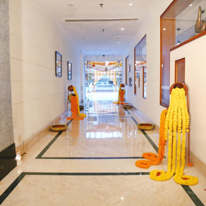 Lobby corridor at The Bristol Hotel, Gurgaon decorated with flower garlands on flower pots.