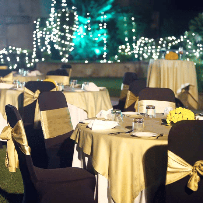 An outdoor space with chairs, tables, and lights set up for an event. | The Bristol Hotel
