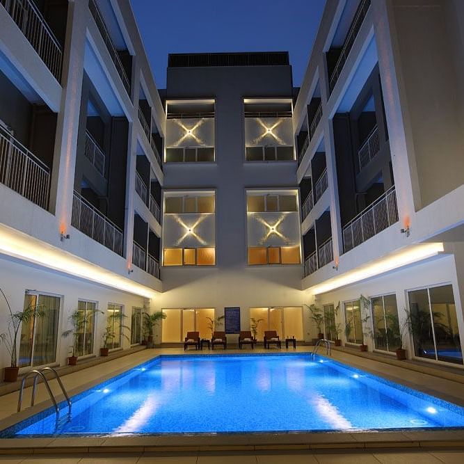 Swimming pool in the night with the lights on - Starlit Suites, Kochi