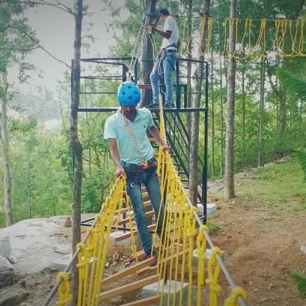 image of a man balancing himself through the Earthquake Bridge at our hotel in yercaud