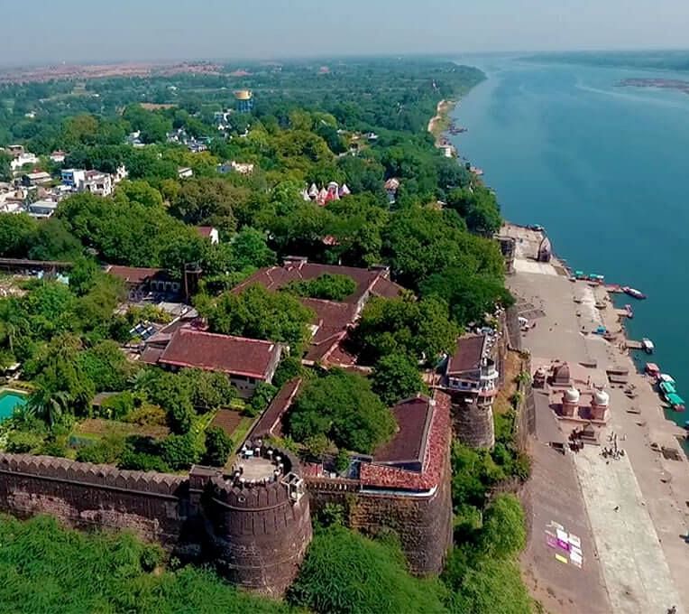 A drone shot of Ahilya Fort beside a river