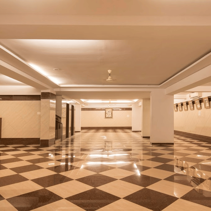 Large, open banquet event space featuring prominent pillars, white walls, and an expansive checkered floor.