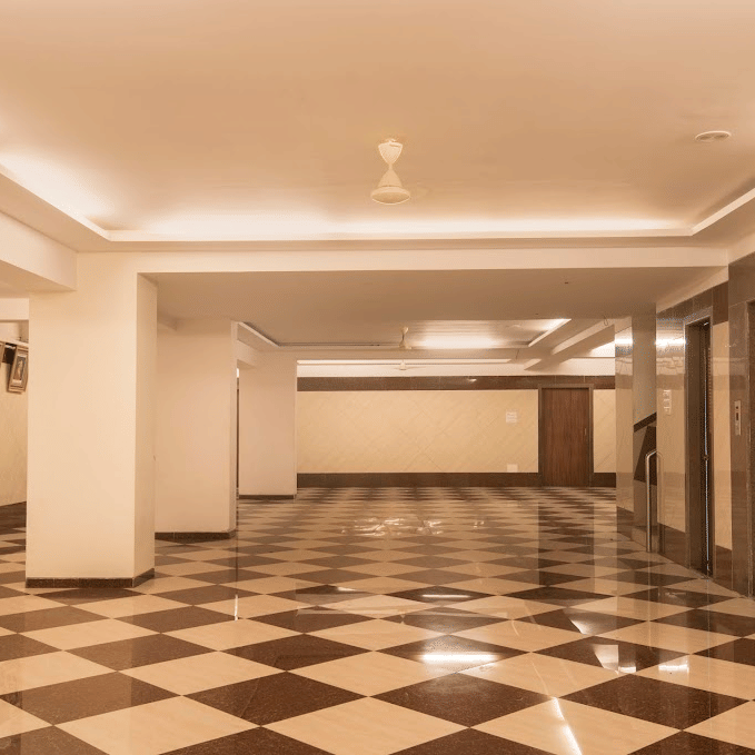 Wide angle shot of a clean, empty conference or banquet hall with distinct brown and white tiled floors.