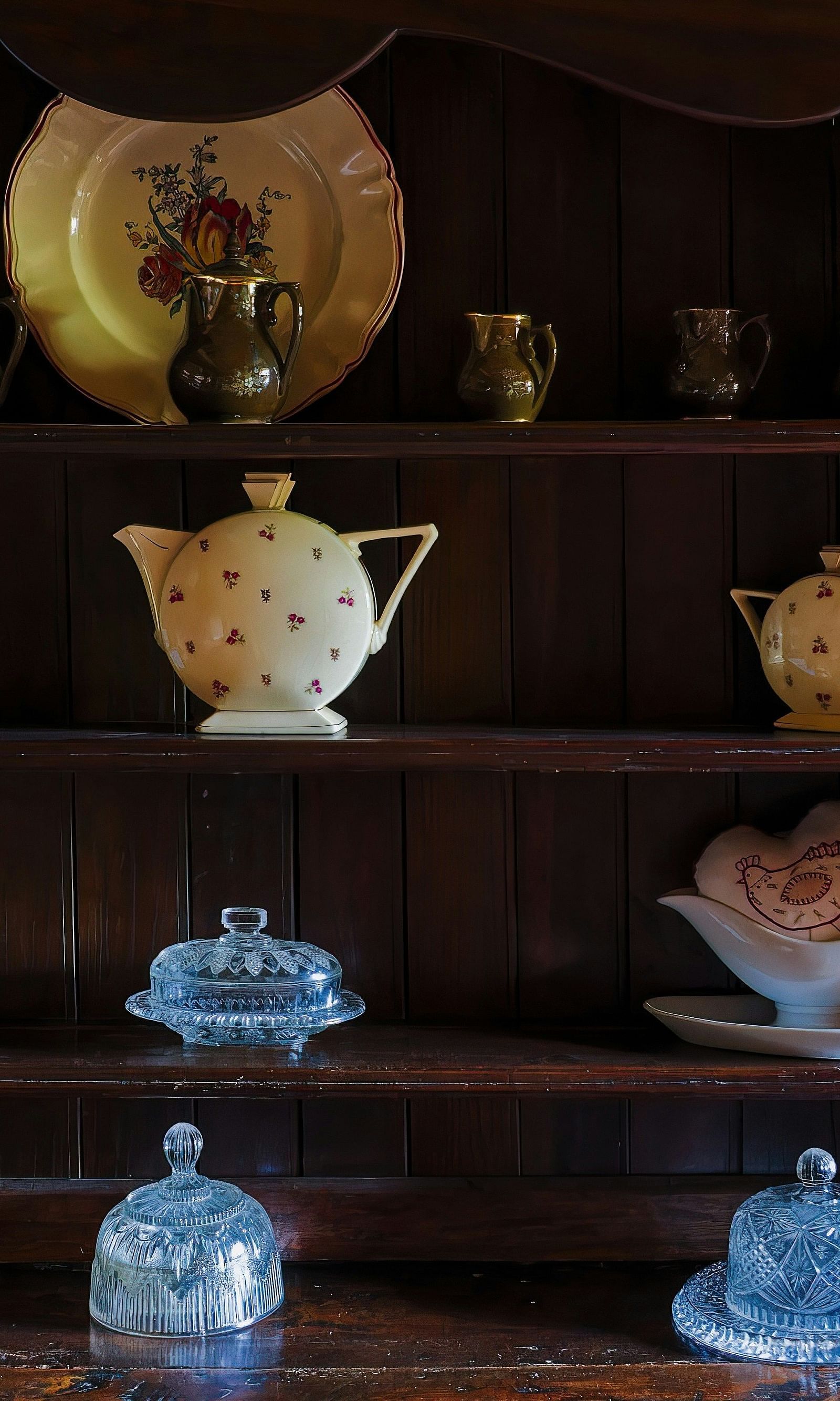 An image of a vintage shelf with tea cups, saucers and kettles
