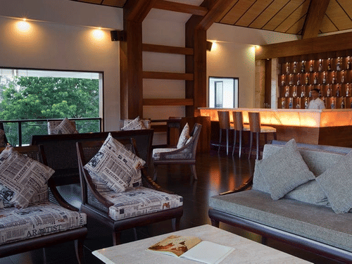 seating area at the Blue Sky Lounge featuring a seating space with couches around a coffee table under warm lighting and greenery view from the window