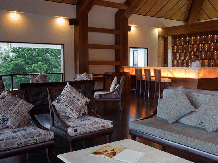 seating area at the Blue Sky Lounge featuring a seating space with couches around a coffee table under warm lighting and greenery view from the window