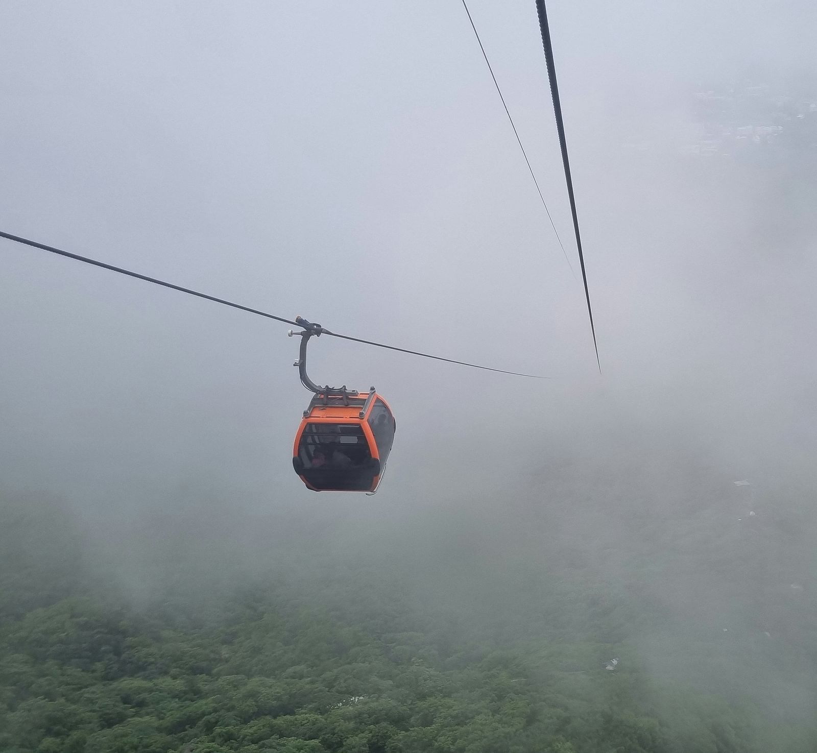 image of a cable car going through the misty mountain valley