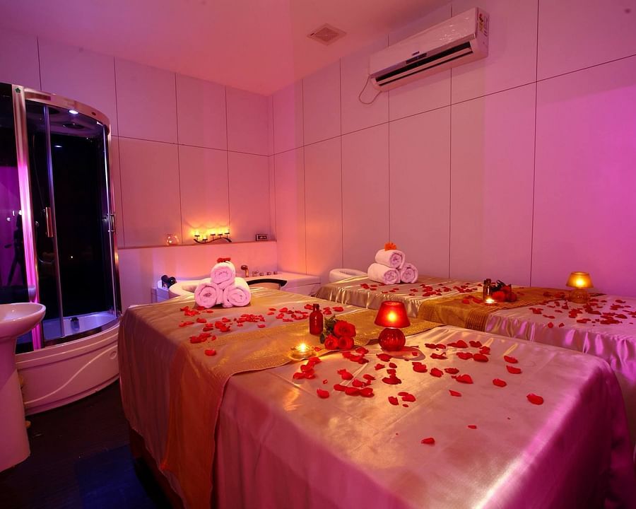 a massage bed with rose petals on them at the in-house spa in Chennai - Raj Park Hotel, Chennai