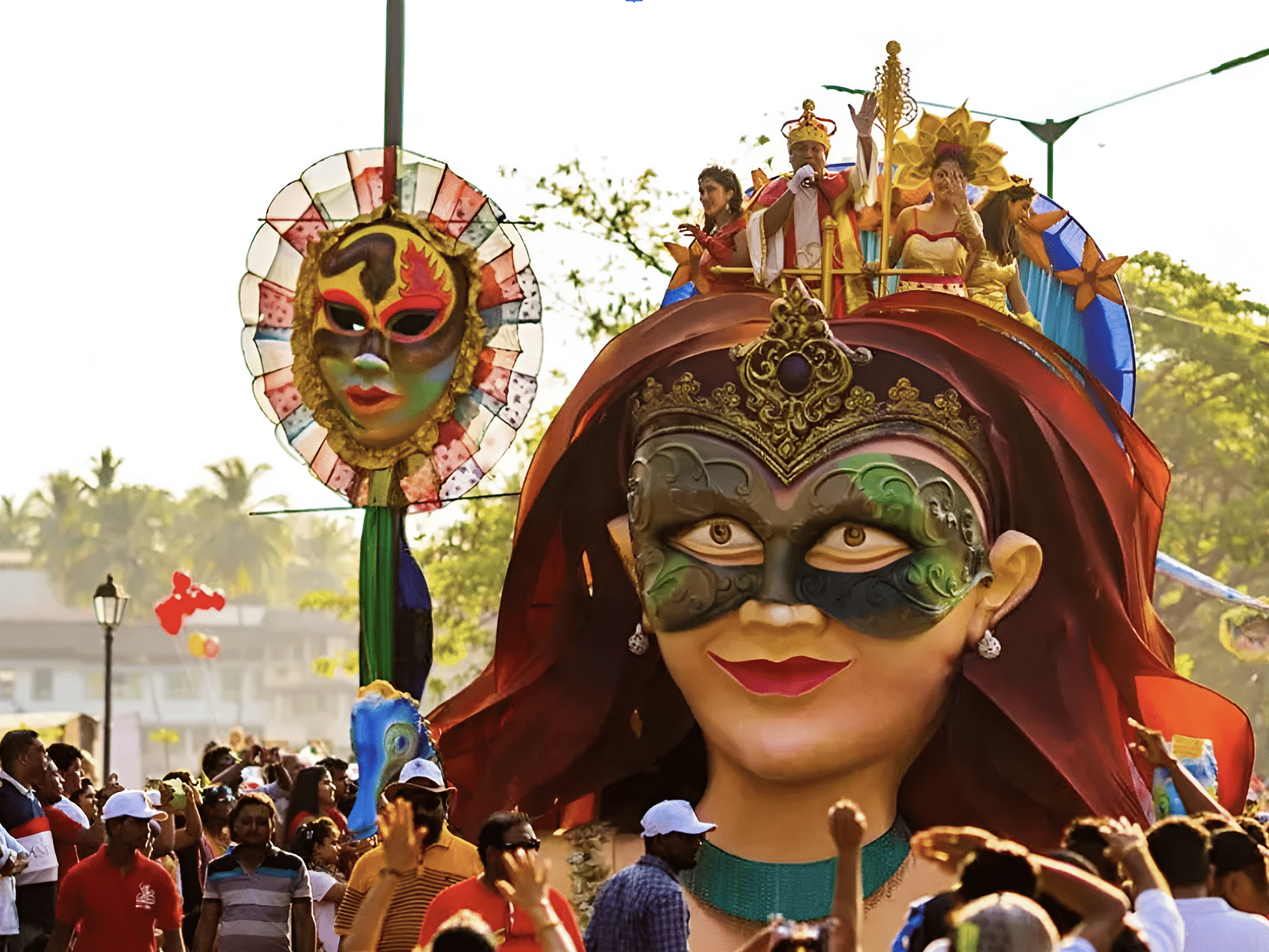 A large, colorful effigy, part of a religious procession or festival in Goa, carried through a crowd.