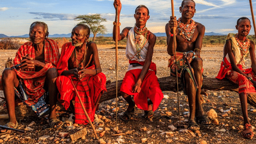 A group of people sitting together with the text Bomas of Kenya.