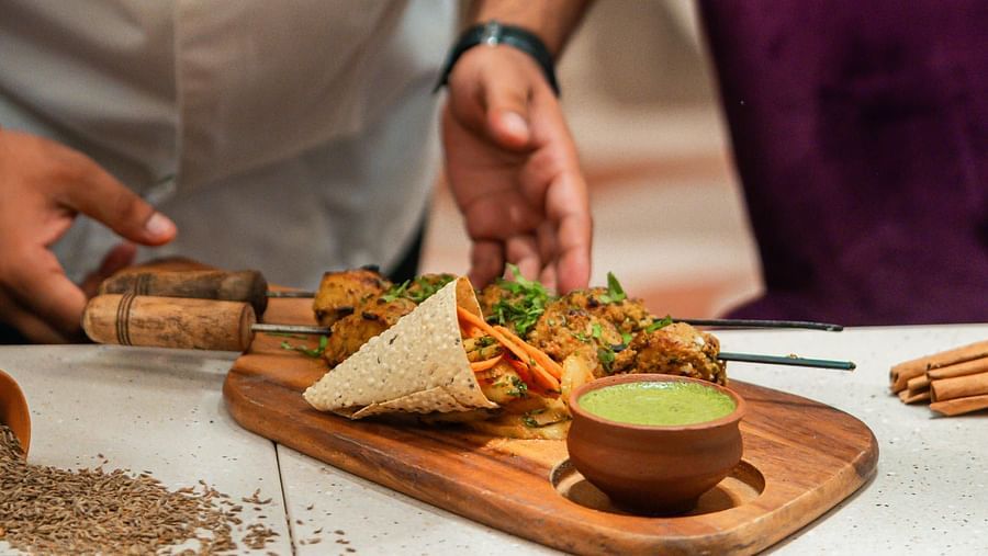 Guests are treated to delicious cuisine served by a chef at Courtyard Fine Dine, Crescent Spa & Resort, Indore