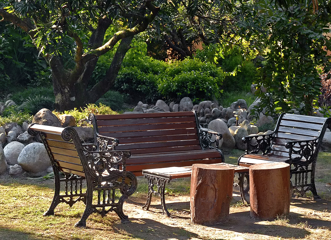 Outdoor seating arrangement with a bench and stool near hotel entrance.