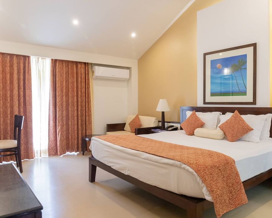 The king size bed in the premier room with peach coloured blanket at Kyriad Prestige Calangute, Goa