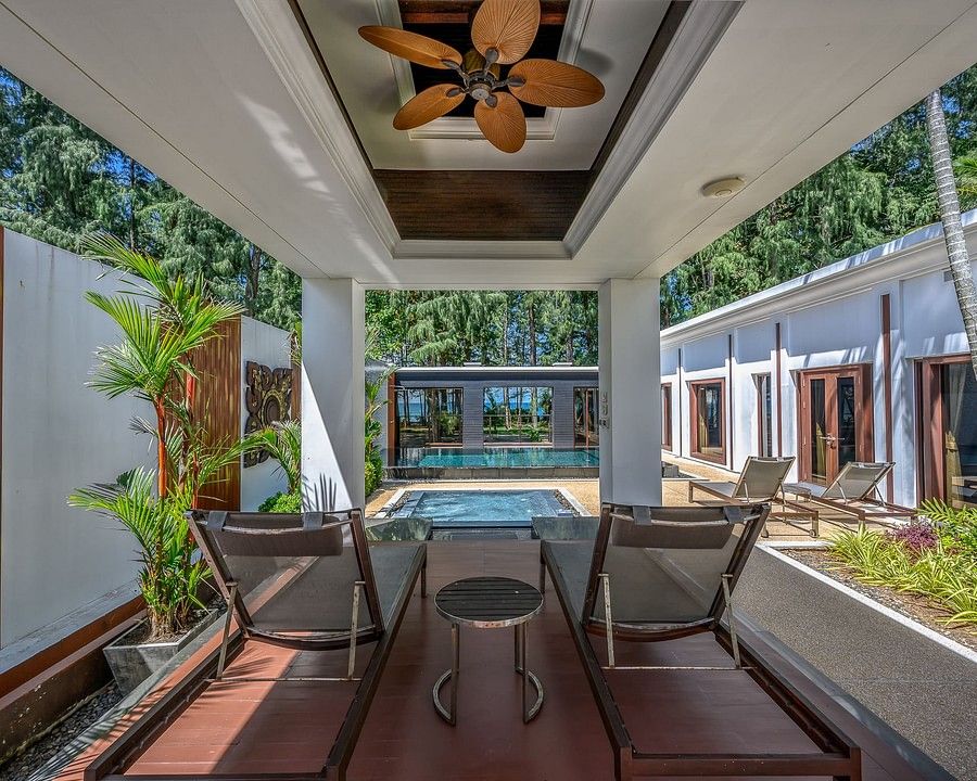 alt-text image of a two chairs in a shed facing the swimming pool - one bedroom private pool beachfront villa