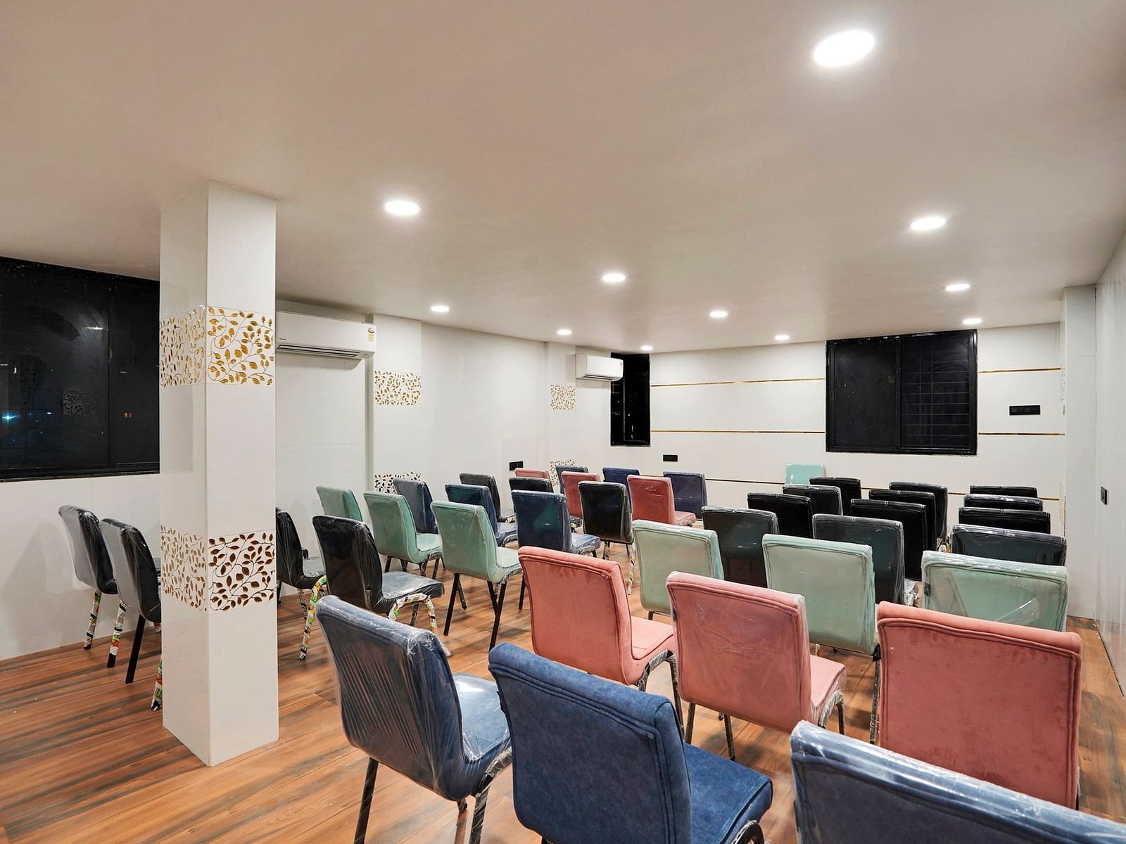 A conference hall with chairs facing the screen at Hotel Regal Heaven, Pune.