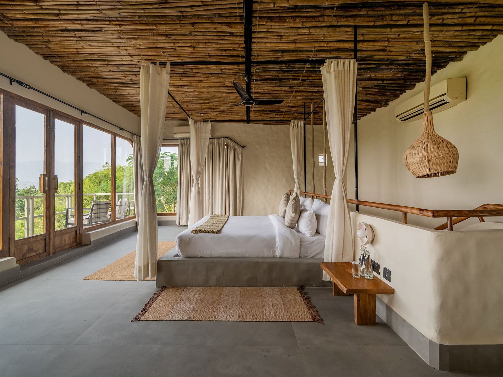 Bedroom with canopy bed, wooden ceiling, and large windows opening to a scenic view.