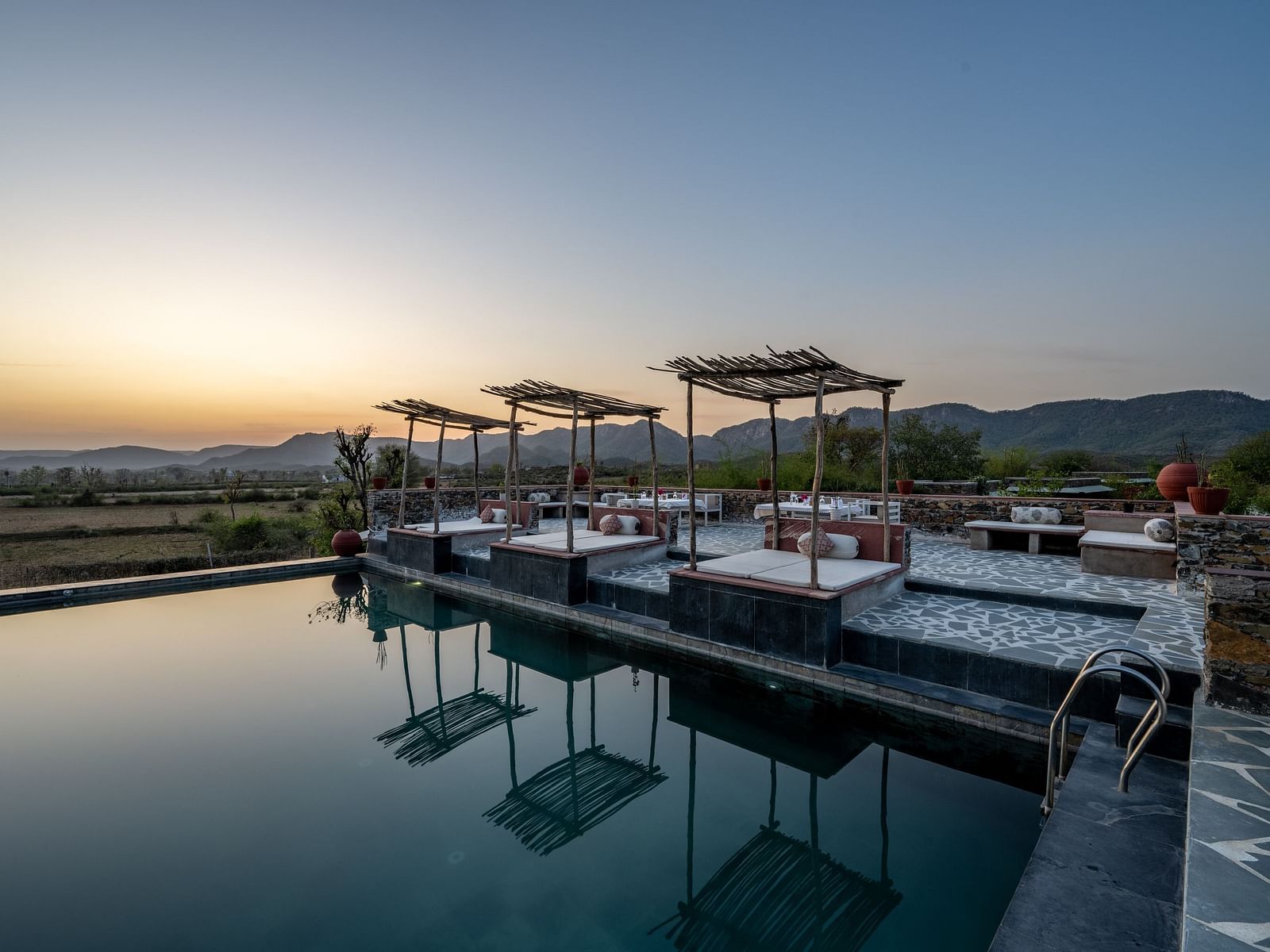 An image of a seating arrangement near the swimming pool in the open - Utsav Camp Sariska