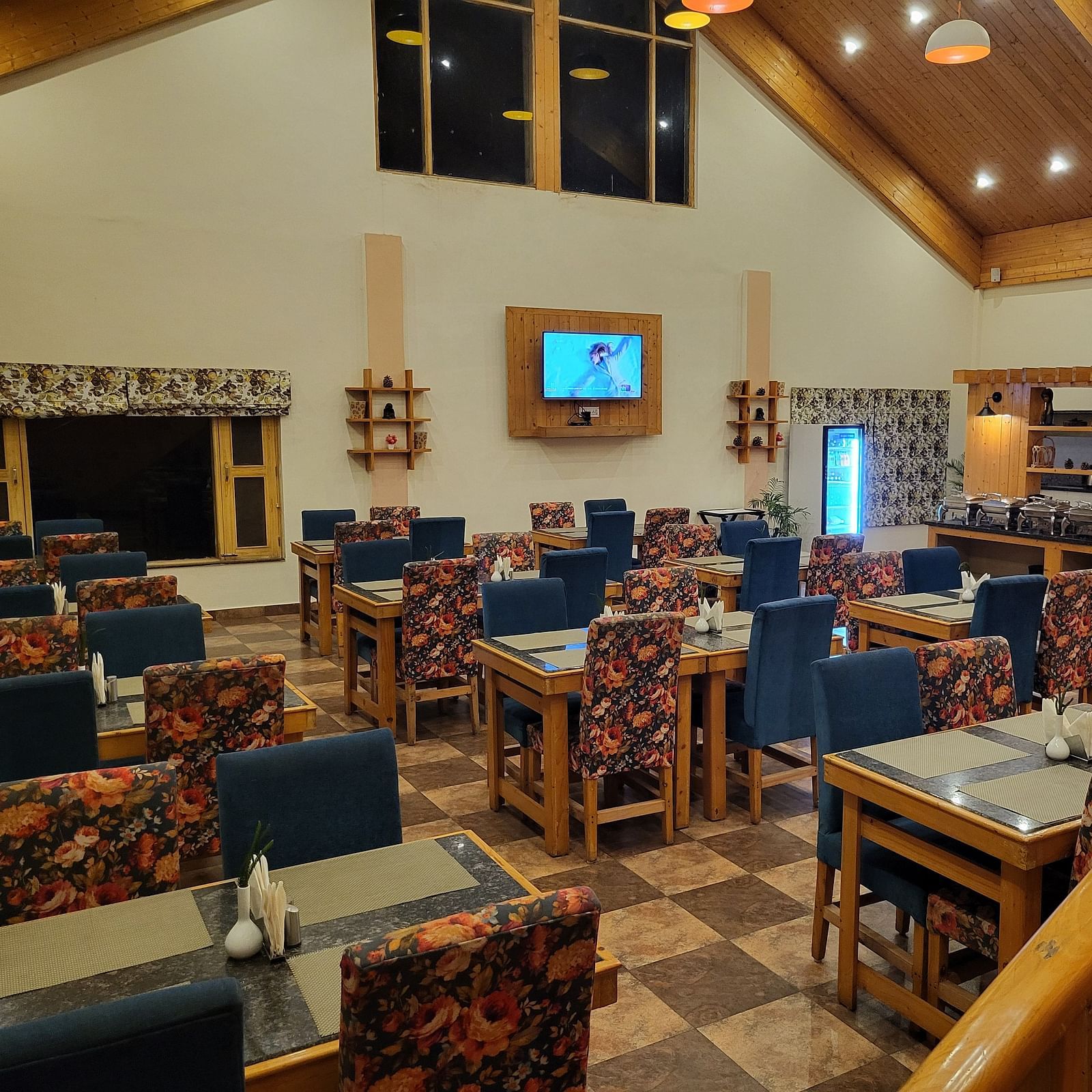 A closer view of the dining space with wooden furniture, ambient lighting, and a cosy setting at Dagshai Manor Kasauli - Inde Hotels.
