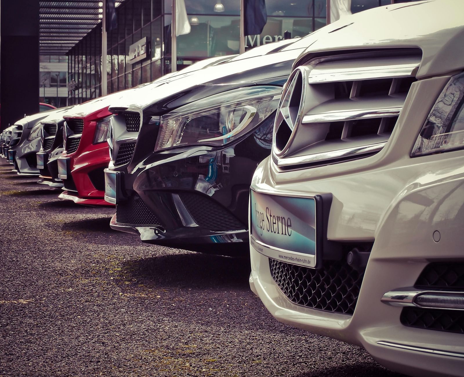 A close up shot of several cars parked in a line in an outdoor area.