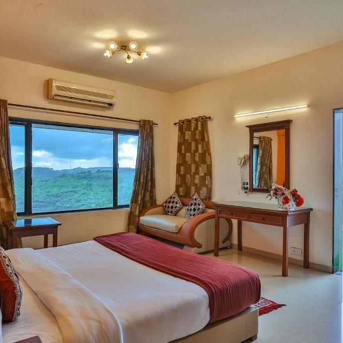 a bedroom with a large window and a bed in the centre - Camel Valley Resort, Igatpuri