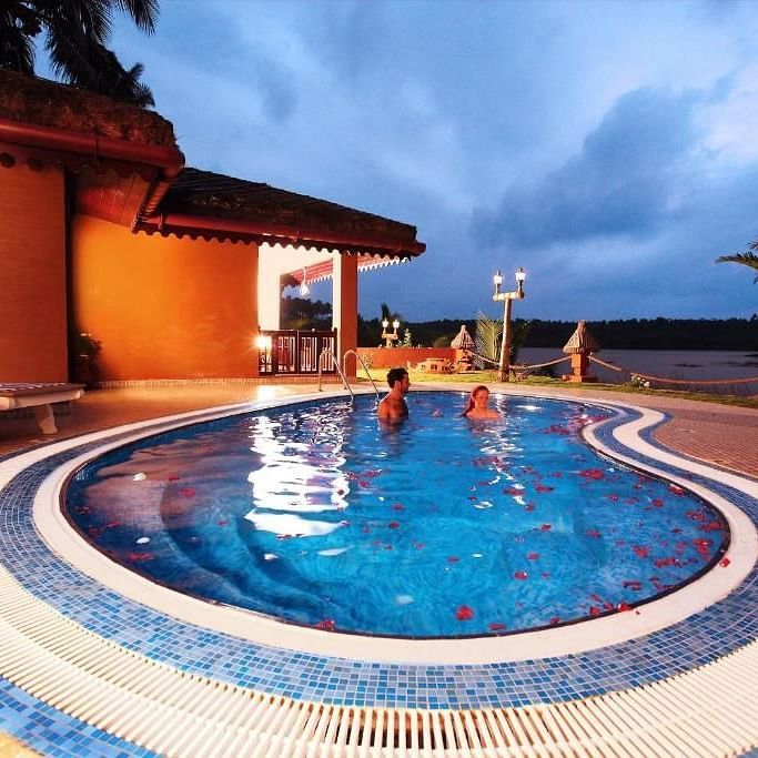 Swimming pool adjacent to the building, with decorative tiled borders around the water.