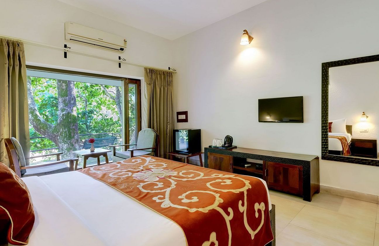 Image of a family room with bed a larg mirror at Summit By The Ganges Beach Resort & Spa, Rishikesh