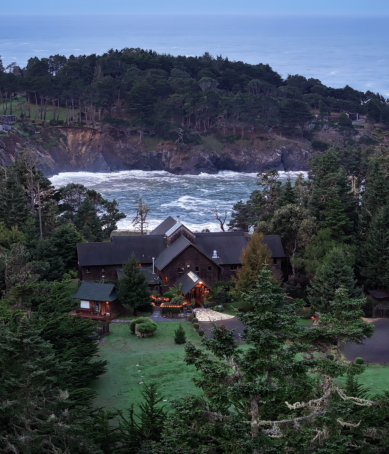 Waves of Mendocino coast crashing against the shore situated behind a hotel - Brewery Gulch Inn & Spa