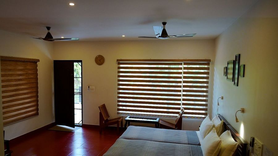 A living area with a couch, a window with blinds, and a ceiling fan.