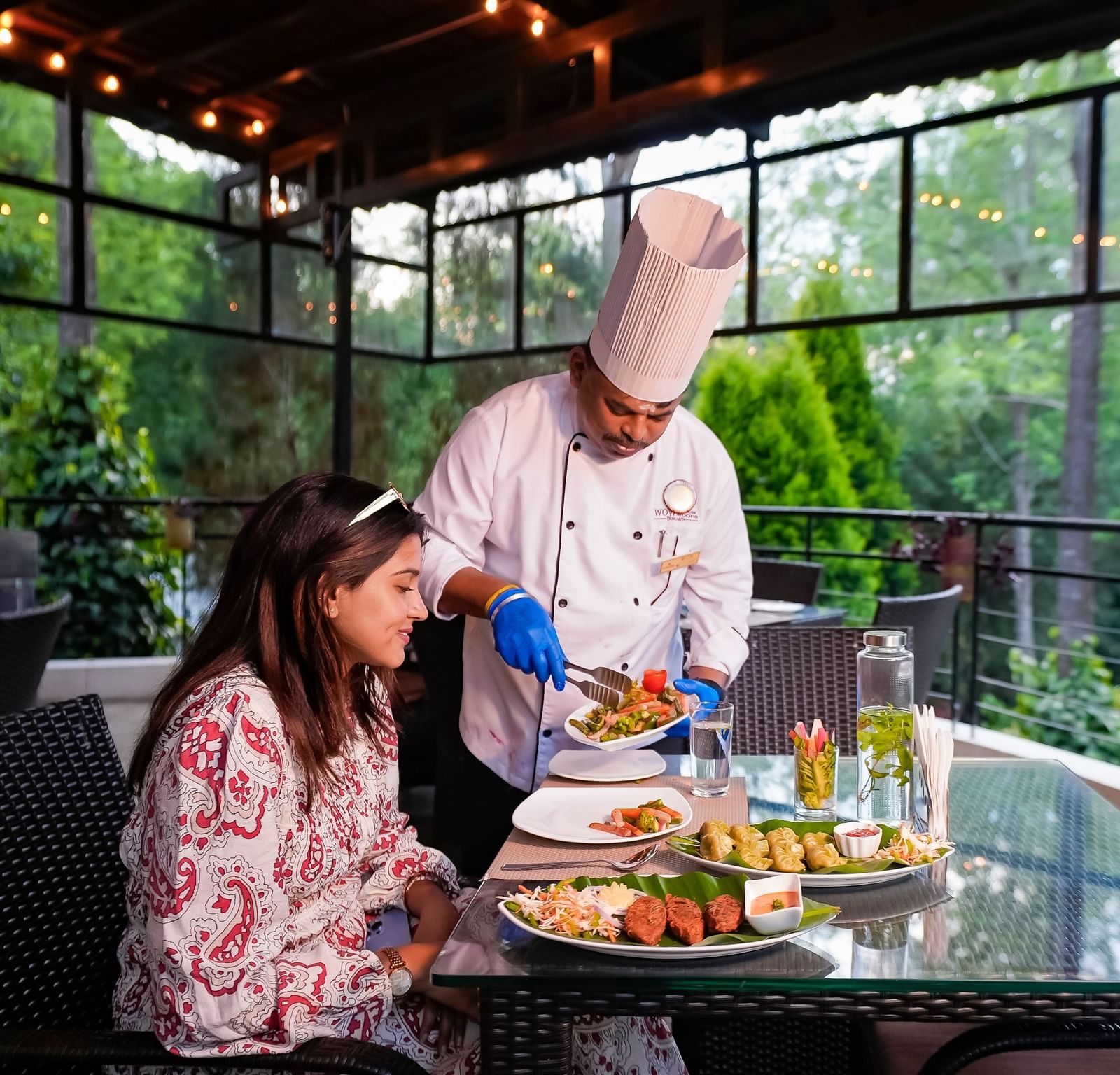 A chef serving food to a lady at WOW Bungalow, Yercaud.